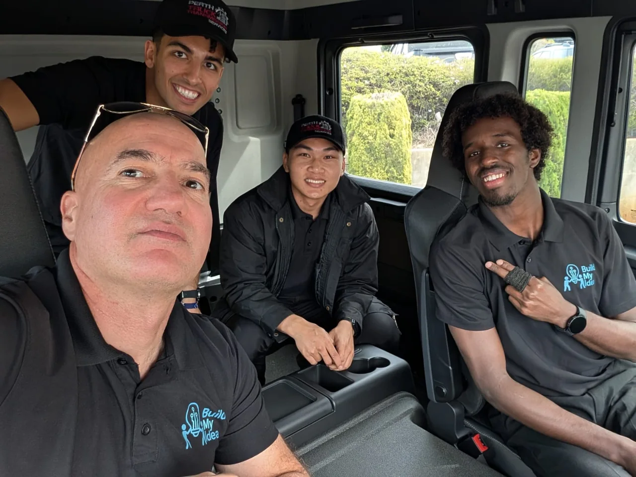 Four Build My Idea team members inside a truck cab